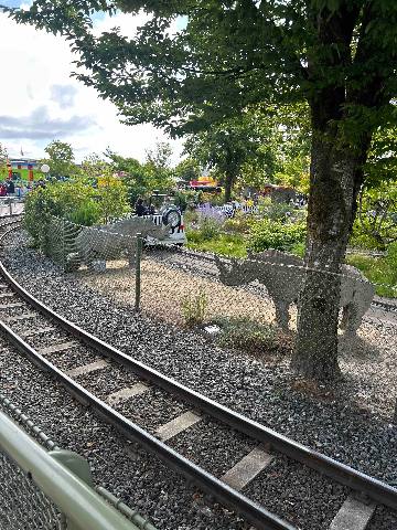 a miniature railway track passing brick-built animal sculptures in a park