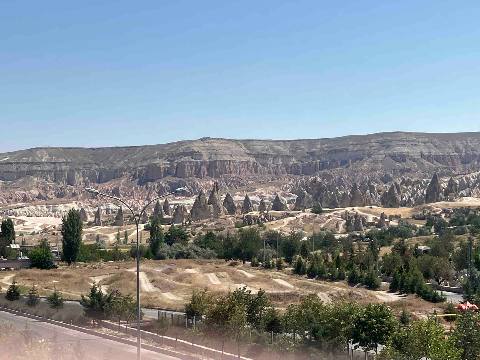 Goreme, Goereme — a wide-angle shot of a rocky valley with hoodoos and a cliff background