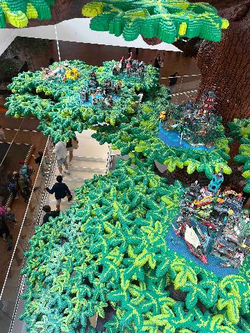 a detailed model tree made of plastic building blocks inside a building
