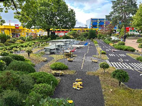 A miniature airport display in an outdoor park setting.