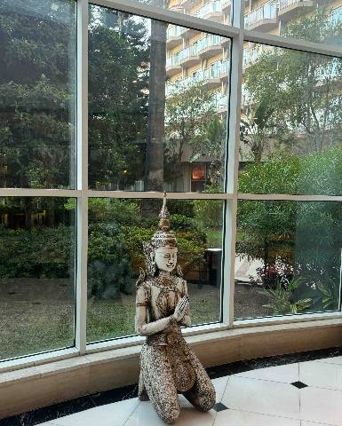 Antalya, Belek, a statue inside a lobby window looking out onto a building and garden