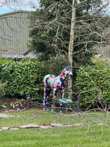 a decorated horse statue in a garden setting