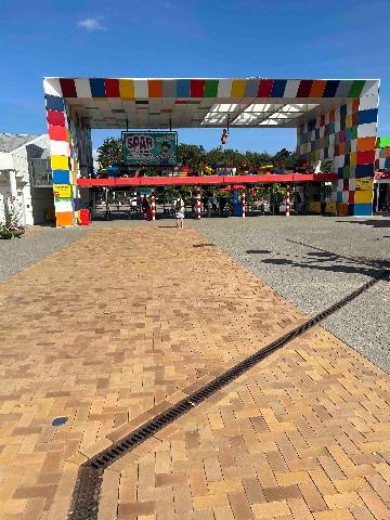 An entrance gate constructed of colourful interlocking toy-like blocks at an outdoor park.