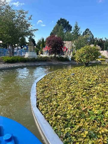 a view of a miniature theme park with a canal and landscaping