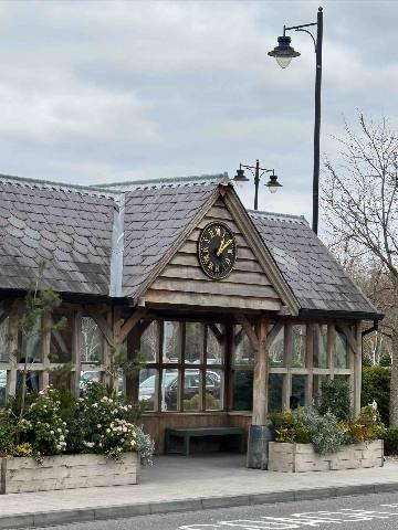 Dublin, Kildare, a timber-framed building with a clock and outdoor planters in a public space