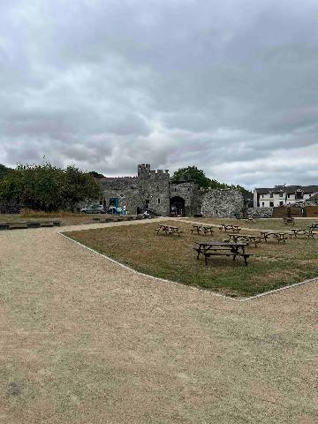 a medieval stone castle with an outdoor courtyard and picnic tables