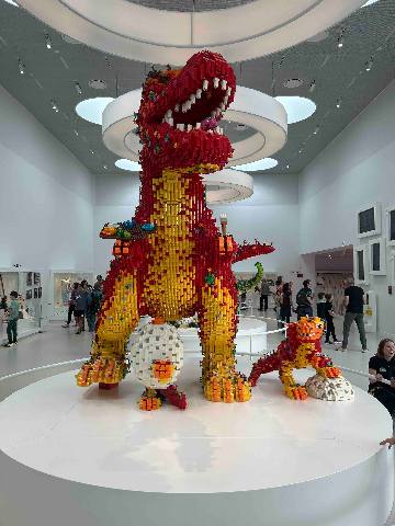 a large plastic brick dinosaur sculpture in a museum