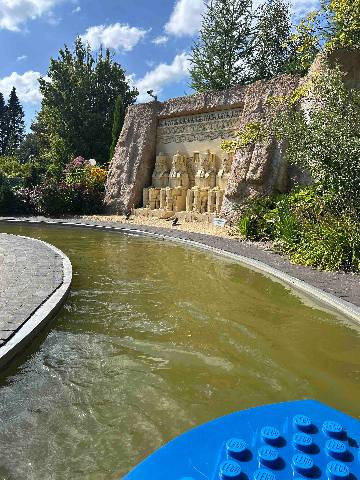 a water ride at a theme park featuring a miniature replica of ancient stone statues
