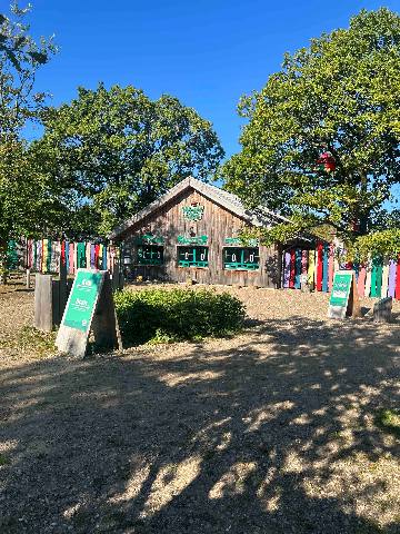 a wooden structure in a park with decorative painted fencing