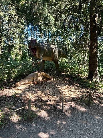 dinosaur models in a wooded park setting