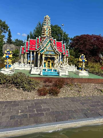 a scale model of a temple made of plastic building blocks in an outdoor setting