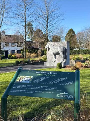 Kildare, a stone horse statue and an informational sign in a park setting