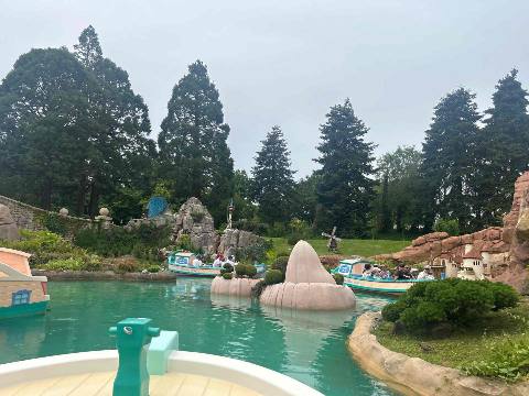 a boat ride on a canal in a park with landscaping and rock formations