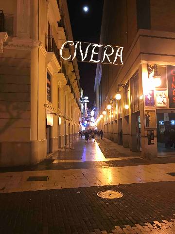 Barcelona, El Clot, a pedestrian city street at night with illuminated signage and architecture