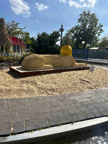 a miniature brick model of the sphinx in an outdoor park