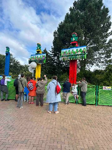 a group of people watching an amusement park ride in Billund